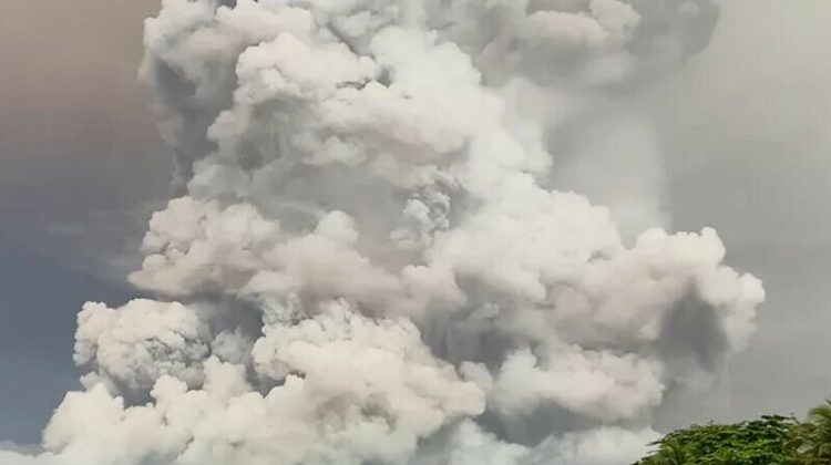 A massive cloud of volcanic ash rising high into the sky, forming thick white and gray plumes after a powerful eruption.