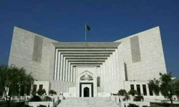 Front view of the Supreme Court of Pakistan building under a clear blue sky.
