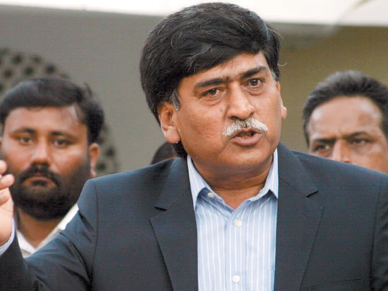 Afaq Ahmed, chairman of MQM-H, speaking to the media with supporters standing behind him.