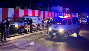 Ambulances and emergency responders at the scene of an Israeli airstrike in Sidon, Lebanon at night, with flashing lights and rescue teams assisting victims.