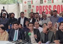 MQM Pakistan leadership addressing a press conference with party members seated and standing behind them.