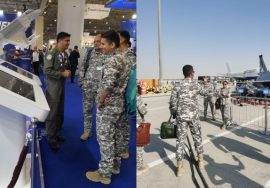 Indian Air Force personnel interacting with Pakistan Air Force officers at the Dubai Airshow, observing Pakistani aircraft and defense technology displays.
