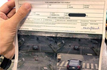 A person holding an e-challan ticket showing a traffic violation with CCTV images captured at a signalized intersection.