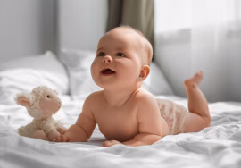 A newborn baby sleeping peacefully while holding a soft stuffed animal, wrapped in a cozy blanket.