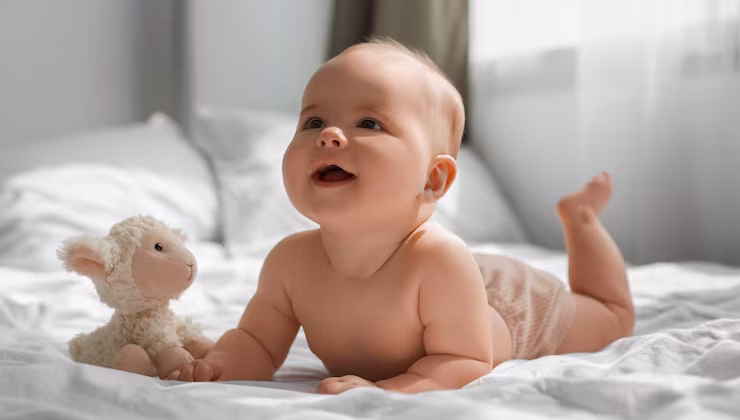 A newborn baby sleeping peacefully while holding a soft stuffed animal, wrapped in a cozy blanket.