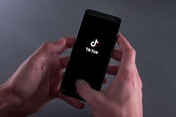 A breaking news graphic showing a smartphone displaying the TikTok logo, alongside Urdu text announcing new TikTok AI controls and educational tools. The layout includes a headline box on the left and an image of hands holding a phone on the right.