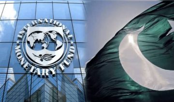 The image shows the International Monetary Fund (IMF) building with its official logo on the left side, while the flag of Pakistan waves prominently on the right side.