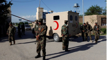 Taliban armed fighters stand guard near a Red Crescent vehicle during a security operation in Afghanistan.