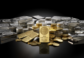 "Gold and silver bars with coins displayed on a reflective surface — premium fine gold 999.9 bullion and silver stacks representing rising gold prices in Pakistan."