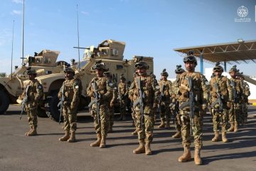 "Pakistan security forces standing in formation with armored military vehicles during a counter-terrorism operation."