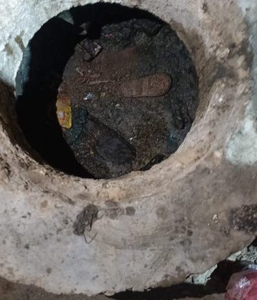 An open sewer manhole on a street in Karachi, posing a serious danger to pedestrians and children