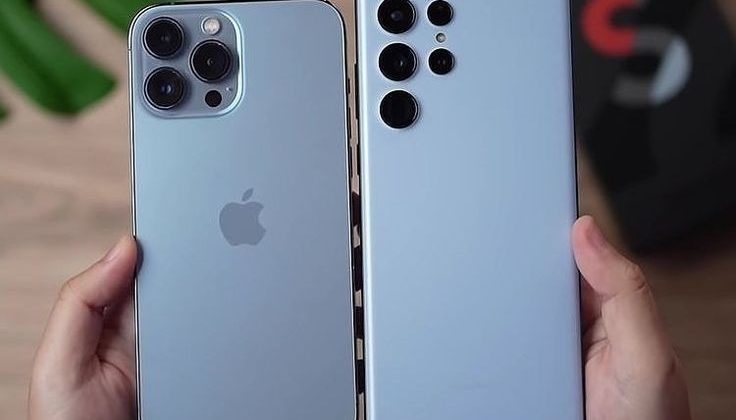 "Two modern smartphones held side by side, showcasing their rear camera designs in a comparison view."
