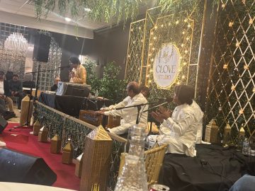 "Qawwali performance at Clove Studio with musicians singing live on stage in a decorated indoor event setup."
