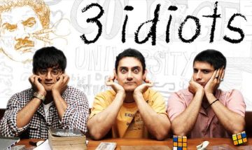 "Main cast of the Bollywood film 3 Idiots sitting at a desk with humorous expressions, featuring Aamir Khan, R. Madhavan, and Sharman Joshi."