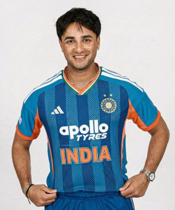 "Indian cricketer smiling in official Team India blue jersey during a photoshoot"
