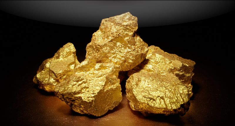 Raw gold nuggets displayed against a dark background, representing gold prices and the precious metals market