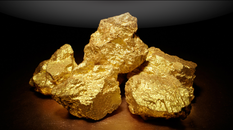 "Shiny gold nuggets placed together on a dark surface, highlighting their natural texture and metallic glow."