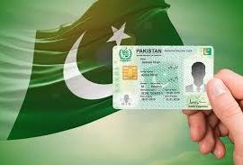 A hand holding a Pakistani National Identity Card (CNIC) in front of a waving Pakistan flag with a green background.